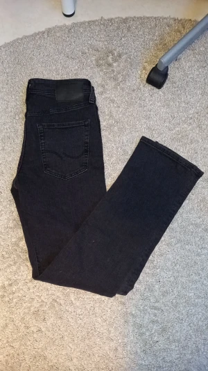 Svarta slim jeans Jack & Jones - Säljer ett par svarta jeans från Jack & Jones, modell Slim/Glenn. Jeansen har fem fickor, bälteshällor och klassisk knapp- och dragkedjestängning. Passformen är slim och materialet är jeans med en mörk ton. Perfekt för dig som gillar stilrena och smala jeans. Köpta för 1199 i butik, dem är hellt nya. pris kan diskuteras vid snabb affär🤗