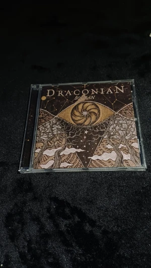 Draconian Sovran CD - Draconian Sovran CD-album i originalfodral från Napalm Records. Fodral och skiva i mycket gott skick, med komplett omslag och booklet. Perfekt för samlare och fans av doom metal. Inga synliga repor eller skador på skivan eller fodralet.