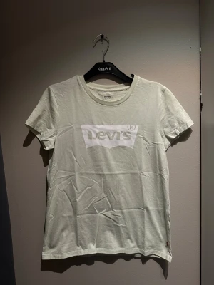 Vit Levi's t-shirt med logga - Fräsch vit t-shirt från Levi's med klassisk logga tryckt i vitt på bröstet. Rund halsringning och korta ärmar. 