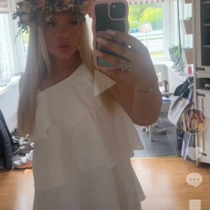 Vit omlottklänning med volanger - Superfin vit kortklänning med volanger och oneshoulder-design. Använd endast två gånger! Stolek 170!