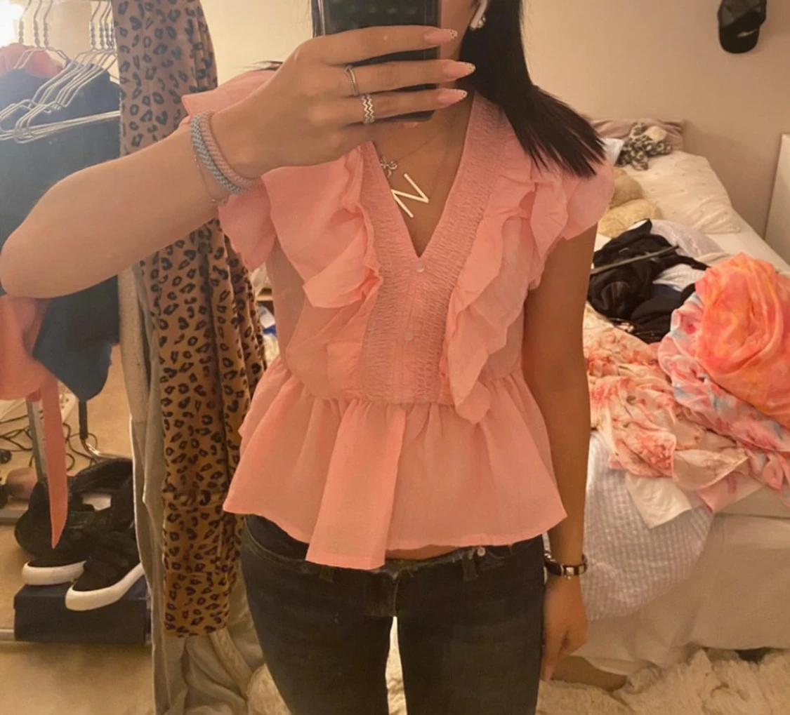 Rosa blus med volanger