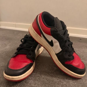 Air Jordan 1 Low ’Bred Toe’ - Säljer Air Jordan 1 Low ’Bred Toe’ i storlek 38. Klassisk och eftertraktad färgkombination i rött, svart och vitt. Snygga, bekväma och perfekta till både vardags och streetwear–looks. I fint skick och redo för en ny ägare!