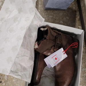 Bruna boots från Canada Snow - Snygga bruna boots i skinn från Snow med dragkedja och spänne på sidan. Perfekta för höst och vinter med en robust design och bekväm passform. De har en stilren look som passar till många olika outfits.