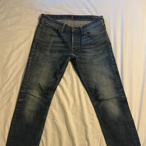 Blå jeans från NN07 med straight fit - Snygga blå jeans från NN07 med klassisk femficksdesign och läderpatch bak. Jeansen har en rak passform, slitningar och tvättade detaljer som ger en cool.