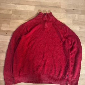 Röd stickad half zip-tröja Chaps XL - Säljer en röd stickad tröja från Chaps i storlek XL. Tröjan har ribbad krage och muddar, samt en half zip-dragkedja vid halsen. Mjuk och grovstickad känsla, perfekt för kyliga dagar. Mått: 49 cm över axlarna, 63 cm längd.