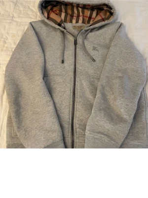 Burberry Hoddie S  - Säljer min Burberry hoddie som har blivit för liten för mig. Hoddien är i bra skick och väldigt stilren, grå på utsidan och det klassiska burberry mönstret på insidan. (Autentiskt)