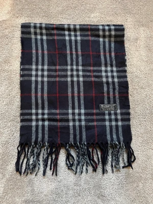 Burberry halsduk - Tidlös Burberry scarf i klassiskt rutmönster med fransar. Mjuk, varm och lätt att styla till både vardag och ytterplagg. | 100 % kashmir | Mått: ca 168 × 30 cm | Mycket bra skick | Hör gärna av dig vid frågor eller funderingar 😁|