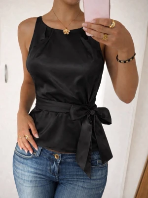 Svart satinlinnetopp med Knyt - Säljer en svart linnetopp från Reserved i glansigt satinmaterial. Kommer inte till användning, har dragkedja åt sidan som inte syns när man bär toppen så det blir lättare att dra på sig. passar xs! 🩷