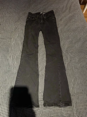 Svarta bootcut jeans från 157 short  - Säljer ett par svarta bootcut jeans från 157 med låg midja. Klassisk femficksmodell och snyggt utsvängda ben. Jeansen är i ett mjukt denimtyg som sitter skönt och ger en avslappnad look. Perfekta till sneakers eller boots.