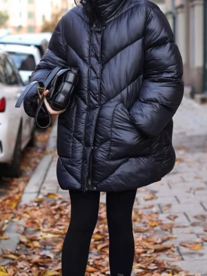 Svart oversized pufferjacka - Säljer en svart oversized pufferjacka med hög krage och dragkedja framtill. Jackan har ett quiltat mönster och stora fickor på sidorna. Varm jacka från märket Blomst. 