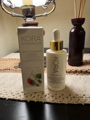 Kora Organics Silky Sun Drops SPF 30 - Oöppnad. Säljer Kora Organics Silky Sun Drops, ett mineralbaserat solskyddsserum med SPF 30. Kommer i en vit glasflaska med pipett och gulddetaljer, 30 ml. Perfekt för dig som vill ha ett lätt serum som skyddar huden mot solen och ger en fräsch känsla.