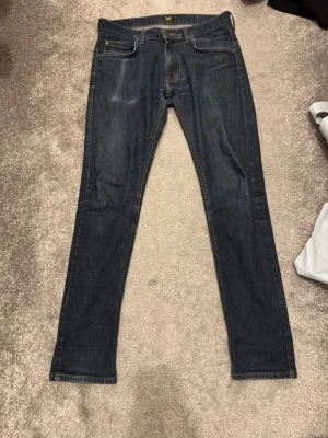 Mörkblå jeans från Lee - Säljer ett par mörkblå jeans från lee. Jeansen har en slim passform. W30 L32. Hör av dig vid fler frågor!