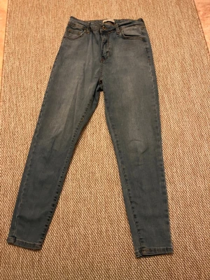 Blå skinny jeans med hög midja - Säljer ett par klassiska blå skinny jeans med hög midja. Hela jeansens längd är 84 cm!😊