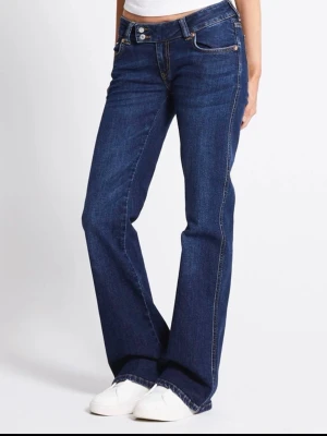  blå bootcut jeans - Säljer ett par klassiska Lagar 157 jeans i blå tvätt. De har låg midja, bootcut-ben och fem fickor. Jeansen är gjorda i slitstarkt denim med snygga kontrastsömmar och metallknappar. Perfekta för dig som gillar en tidlös och avslappnad look. De är ljusare i verkligheten!! Normal i storlek pris kan diskuteras 