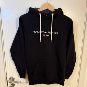 Tommy Hilfiger hoodie – knappt använd! - Säljer en stilren hoodie från Tommy Hilfiger i storlek XS-S.Den har bara använts ca 9–10 gånger och är i väldigt fint skick. Fick den i julklapp men den kommer tyvärr inte till användning.  Nypris ca 1500 kr, säljer nu för endast 449 kr – priset kan diskuteras.  Jag har även en likadan hoodie i grått (också i finare  skick). Om du vill ha båda kan du få dem för 750 kr totalt! Skriv gärna om du vill ha fler bilder eller vill slå till direkt! 