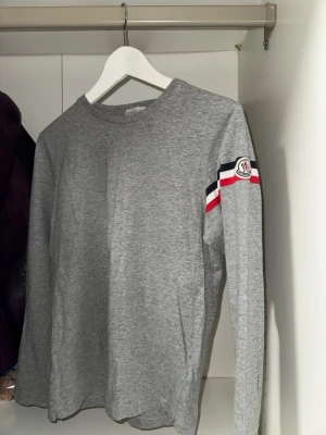 Grå moncler tröja - Säljer en moncler tröja i grå färg med moncler logga på armen. Bra skick och självklart äkta, äktehetsbevis finns. Skriv om det finns några frågor!