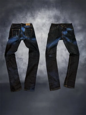 Nudie Jeans  - Säljer ett par mörkblå Lean Dean jeans från Nudie Jeans i modellen Dry Slow Dark. Jeansen har klassisk femficksdesign.