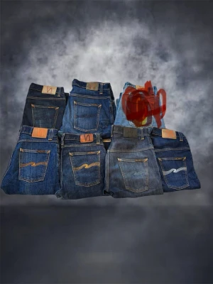 Blå jeansbyxor från Nudie Jeans, kolla min profil eller skriv vid intresse - Säljer flera par klassiska blå jeans från Nudie Jeans med deras ikoniska vågmönster på bakfickorna. Jeansen har olika tvättar från mörkblå till ljusare blå och är tillverkade i slitstark bomull. Perfekta för dig som gillar tidlös och avslappnad stil.