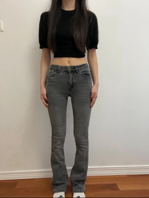 Grå bootcut jeans från Only - Säljer ett par gråa bootcut jeans från Only med lite ljusare ton nere och mörker upptill. Syns knappt med ger en cool effekt. Lite slitna längs nere, men inget som stör. 