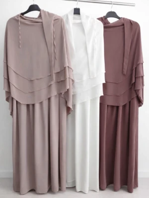 Jilbab med khimar  - Säljer en elegant långklänning Jilbab med khimar med flera lager volang upptill och långa ärmar. Finns i färgerna vit, beige, brun, grå, marinblå och svart. Klänningen har en loose passform och är tillverkad i ett lätt syntetmaterial som faller snyggt.