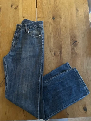 Levi's 630 blå jeans W32 L34 - Klassiska blå Levi's 630 jeans med rak passform och fem fickor. Jeansen har en snygg tvättad look, normal midja och ikonisk läderpatch bak i linningen. Tillverkade i slitstarkt denim av bomull. Perfekta för dig som gillar tidlös stil.