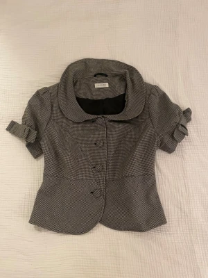 Rutig kortärmad jacka/topp - Vintage Rutig kortärmad inomhus jacka/topp med rosetter och puffärmar. Strl S