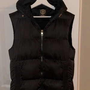 GG Dunväst - En svart Glorious Gangsta Alfrez Gilet Dunväst som inte säljs längre. Köpt på Zalando för 656kr. Inga hål eller fläckar. Passar mig bra som är ca 175 och väger ca 70kg. Storlek M men är större i storleken.