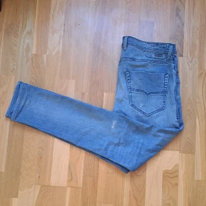 Ljusblå jeans från Diesel - Snygga ljusblå jeans från Diesel med klassisk femficksdesign och diskret slitning på benen. Jeansen har en fin passform och raka ben, perfekt för en avslappnad men trendig look. Tillverkade i mjukt denim-material för skön känsla hela dagen.