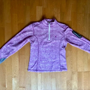 Lilla fleecetröja storlek M från TTL - Mjuk lilla fleecetröja från TTL (xxl.se) i storlek M med halv dragkedja. Tröjan har en liten ficka med dragkedja på vänster ärm. Material: 100% polyester.