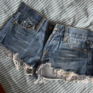Korta shorts  - Ett par korta lågmidjade jeansshorts. Slitna nedtill. Passar storlek xxs-xs 