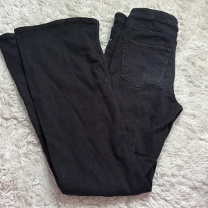 Svarta bootcut jeans från H&M, strl 36/S - Svarta jeans från H&M i klassisk bootcut-modell. Byxorna har fem fickor, bälteshällor och stängs med knapp och dragkedja. Snygg passform med lite utsvängda ben och tillverkade i ett mjukt bomullstyg med stretch. Använt fåtal gånger men de är för korta på mig.