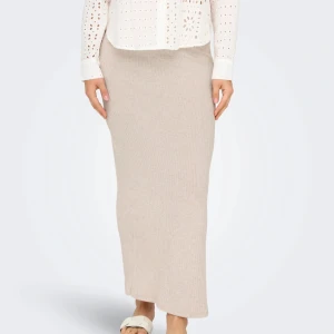 Beige ribbad långkjol med slits - Superfin beige långkjol i ribbstickat material med en snygg slits på sidan. Enkel att matcha med både sneakers och sandaler.