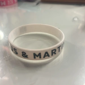 Marcus & Martinus vitt armband - Ett vitt silikonarmband med svart text där det står 'Marcus & Martinus'. Perfekt accessoar för fans som vill visa sitt stöd på ett stilrent sätt. Armbandet är flexibelt och bekvämt att bära hela dagen.   !!pris kan diskuteras!!
