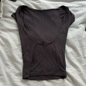 Svart topp med öppen rygg Gina Tricot - Svart, tight topp från Gina Tricot i storlek XS. Modellen har korta ärmar och en öppen rygg. Tillverkad i mjuk bomullsmix som sitter skönt mot kroppen. Perfekt att styla med jeans eller kjol för en clean look. Toppen är inte använd mer än 3 gånger. 