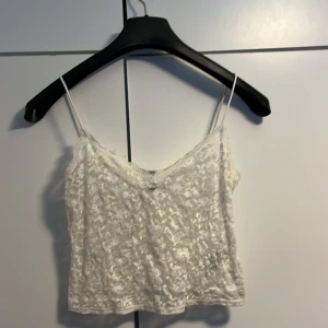 En vit genomskinlig topp - En vit genomskinlig topp som är i ett väldigt bra skick dock den är använd bra tal gånger. 