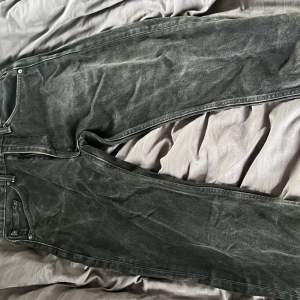 Svarta snygga Levis jeans som är ganska slitna vilket gör dem väldigt coola