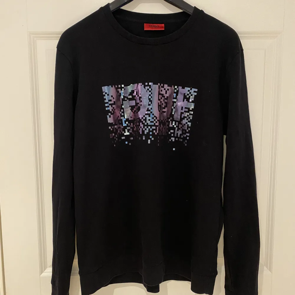 Hugo Boss sweatshirt (svart med silvrigt tryck). Väldigt bra skick som NY. Använd ett fåtal gånger. . Tröjor & Koftor.