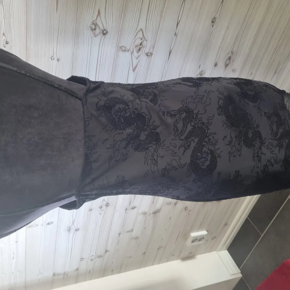 Svart klänning i mesh ifrån hm med svarta drakar i sammet över klänningen  använd 2 gångnger. Klänningar.