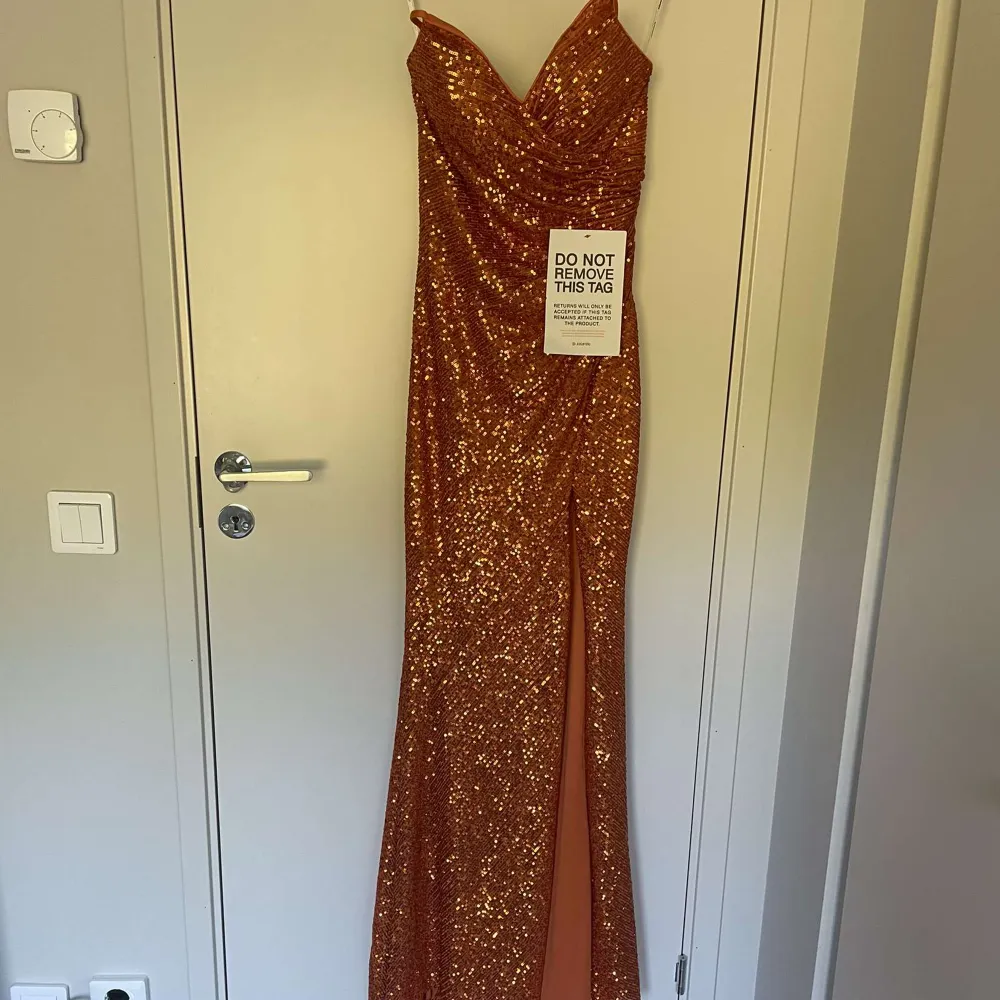 En orange glitter klänning. Ordinarie pris är 2875kr, mitt pris är 1000kr. Den är i ett väldigt bra skick och bara använd en enda gång. . Klänningar.