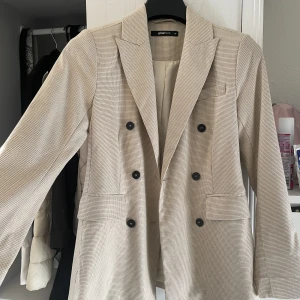 Beige Kavaj - Aldrig använd från Gina. Lite längre kavaj, täcker rumpa 