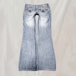 Lågmidjade jeans - Midja:71 innerben:80 Lågmidjade jeans med vida ben. Storlek 36 men skulle säga att de är små i storlek. Mittenknappen saknas men går bra att använda med tanke på de andra knapparna. Smånötta vid ex linning, fickor. Nötta fotändar. Överlag bra skick🤍