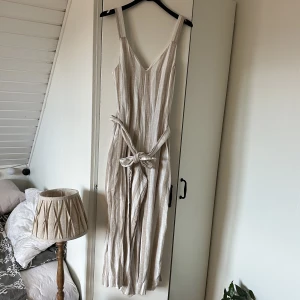Jumpsuit  - Vit och beigerandig jumpsuit från H&M🫶🏼endast använd en gång så väldigts fint skick! 