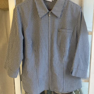 Rutig skjorta - Vintage blus/skjorta som går att ha öppen eller stängs. Knäpp med dold dragkedja. Rak modell med krage och bröstficka. Tunt skönt material. Jättefint skick! 