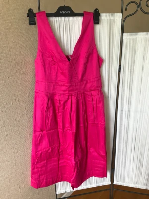 Rosa klänning med skärp - Vacker rosa klänning som går att knyta åt i midjan. Aldrig använd. Hämtas i Huddinge. 