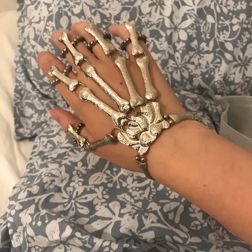 Skeletthand köpt från shein. En del av metallfärgen har försvunnit på baksidan av banden (se bild två) men annars är den i ganska gott skick Skriv gärna för fler bilder. Accessoarer.