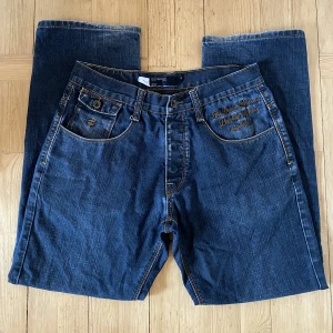 Jeans - Sjukt feta jeans från Rocawear, storlek 34. Säljs då de tyvärr är för stora för mig. Oerhört små slitningar vid ändarna, annars inga slitningar eller defekter. Priset är inte hugget i sten :)