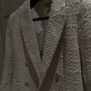 Hm kavaj/kappa - Boucle tvist på kappan med guld detaljer
