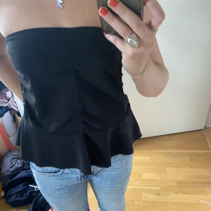Bandeau topp - Super snygg bandeau topp med volang längst ned. Perfekt till fest, middag och vardag! Den har en liten kant högst upp så den åker inte ner! Använd 2 gånger. Passar S-L skulle jag säga!😊