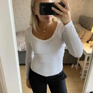 Vit långärmad  - Vit långärmad tröja med djup ringning i ribbat material och därav inte genomskinlig. Storlek M men passar även S🤍