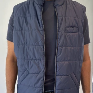 Stenströms väst - Marinblå quiltad väst med en rak passform, stängs med dragkedja framtill. Nypris 2699kr. Sparsamt använd, inga hål eller defekter, köparen står för frakt, köp genom ”köp nu”.